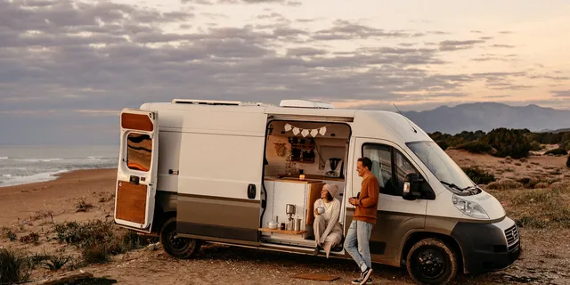 Jessi und Markus in ihrem Van am Strand